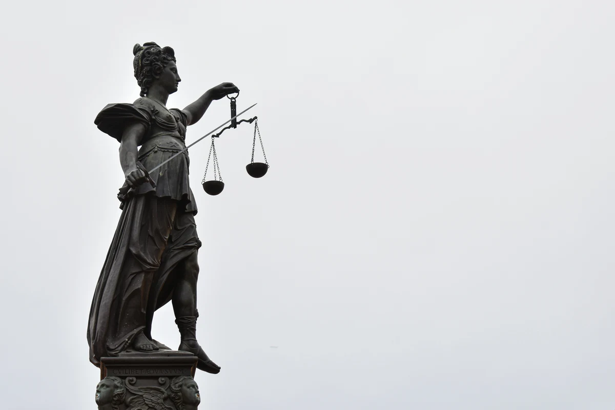Estátua da Justiça com a balança e a espada, contra o céu